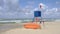 Lifeguard post with a ref flag on it informing about the danger of the wind in the sea