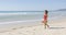 Lifeguard with rescue float walking along beach