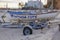 A lifeguard rescue row boat is seen on a vehicle trailer on the sand in storage for the winter