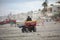 Lifeguard riding a buggy at the ocean beach at sunset.