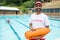 Lifeguard standing with rescue buoy near poolside