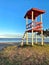 Lifeguard station by the sea with a tree, blue sky in a beautiful afternoon and grass