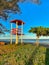 Lifeguard station by the sea with a tree, blue sky in a beautiful afternoon and grass