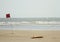 Lifeguard surfboard and red flag on the beach