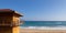 Lifeguard wooden tower station tower. Coastline blue sky