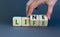 Lifeline, line of life symbol. Businessman hand turns cubes and changes the word `life` to `line`. Beautiful grey background.