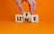Lifeline, line of life symbol. Businessman hand turns cubes and changes the word `life` to `line`. Beautiful orange table, ora