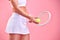 Lifes better on the court. Studio shot of a sporty woman holding a tennis racket and ball against a pink background.