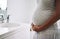 Lifes little miracle. Closeup shot of a pregnant woman standing in the bathroom at home.