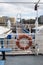 Lifesaver ring on the side of a railing on a ferry docked at a wharf pier