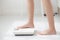 Lifestyle activity with leg of woman stand measuring weight scale for diet with barefoot