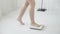 Lifestyle activity with leg of woman walking measuring weight scale for diet, closeup feet of girl slim weighing measuring