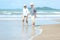 Lifestyle asian senior couple walking happy and relax on the beach.