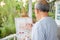 Lifestyle Asian senior old man painting picture artwork using brush and oil color on canvas