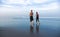 Lifestyle back portrait of young attractive and healthy couple relaxed walking on beautiful desert beach early morning in romantic