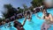 Lifestyle blogger man taking selfie video with action camera in a swimming pool. Travel vlogger films vlog from party at