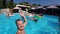 Lifestyle blogger man taking selfie video with action camera in a swimming pool. Travel vlogger films vlog from party at