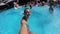 Lifestyle blogger man taking selfie video with action camera in swimming pool. Travel vlogger films vlog from party at