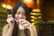 Lifestyle candid portrait of young beautiful and happy Asian Korean woman having breakfast at coffee shop outdoors smiling cheerfu