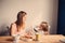 Lifestyle capture of happy pregnant mother and baby girl having breakfast at home