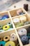 Lifestyle concept, work from home to reinvent your life: close-up detail some colored thread spools in a wooden organizer box with