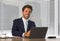 Lifestyle corporate company portrait of young happy and successful business man working relaxed at modern office sitting by window