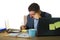 Lifestyle corporate portrait of young attractive busy and confident businessman working at office computer desk writing notes