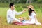 Lifestyle couple picnic and relax. People young woman and man having fun and happy playing guitar picnic in the meadow and field s