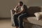 Lifestyle dramatic light portrait of young sad and depressed man sitting at shady home couch in pain and depression feeling lost l