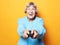 Lifestyle, emotion  and people concept: funny grandma is holding a TV remote over yellow background