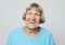 Lifestyle,emotion and people concept: funny grandmother posing over grey background