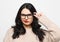 Lifestyle, emotion and people concept - young woman wearing eyeglasses looks incredulously and reflects