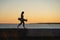 Lifestyle and freedom: young girl with skateboard walk at sunset. Silhouette of trendy female skater