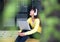 Lifestyle Girl enjoy listening music and play laptop in the nature park.