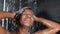 Lifestyle head shot of young happy and beautiful black African American woman smiling happy taking a shower at home bathroom