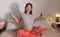 Lifestyle home portrait of young happy and beautiful Asian Korean woman pregnant sitting on bed holding ultrasound photo excited