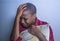 Lifestyle indoors portrait of young sad and depressed black afro American woman sitting at home floor feeling desperate and worrie