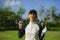 Lifestyle outdoors portrait of young beautiful and happy woman at playing golf holding ball and putter club smiling cheerful in st