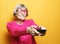 Lifestyle and people concept: funny grandmother is holding a TV
