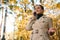 Lifestyle portrait of a business woman, pretty lady talking on mobile phone while walking on the autumnal park, enjoying beautiful