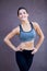 Lifestyle portrait of fitness pretty young woman wearing grey sports bra and black pants. Fresh healthy stylish sport