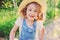 Lifestyle portrait of happy child girl in straw in summer