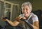 Lifestyle portrait of middle aged attractive and happy Asian Indonesian woman with grey hair training exercise smiling at gym