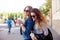 Lifestyle portrait of two happy friend girls walk laugh talk and drink lemonade wearing trendy bright clothes and sunglasses.Girls