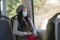 Lifestyle portrait of young attractive and pretty Asian woman wearing mask in railcar traveling in new normal virus time - sweet