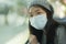 Lifestyle portrait of young attractive and pretty Asian woman wearing mask in railcar traveling in new normal virus time - sweet