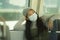 Lifestyle portrait of young attractive and pretty Asian woman wearing mask in railcar traveling in new normal virus time - sweet