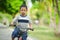 Lifestyle portrait of young happy and excited 5 years old Asian Indonesian child enjoying learning bike at city park isolated on