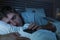 Lifestyle portrait of young tired and exhausted man sleeping or falling asleep while networking in bed late at night in internet