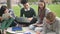 Lifestyle shot of american four person talking using computer along college.